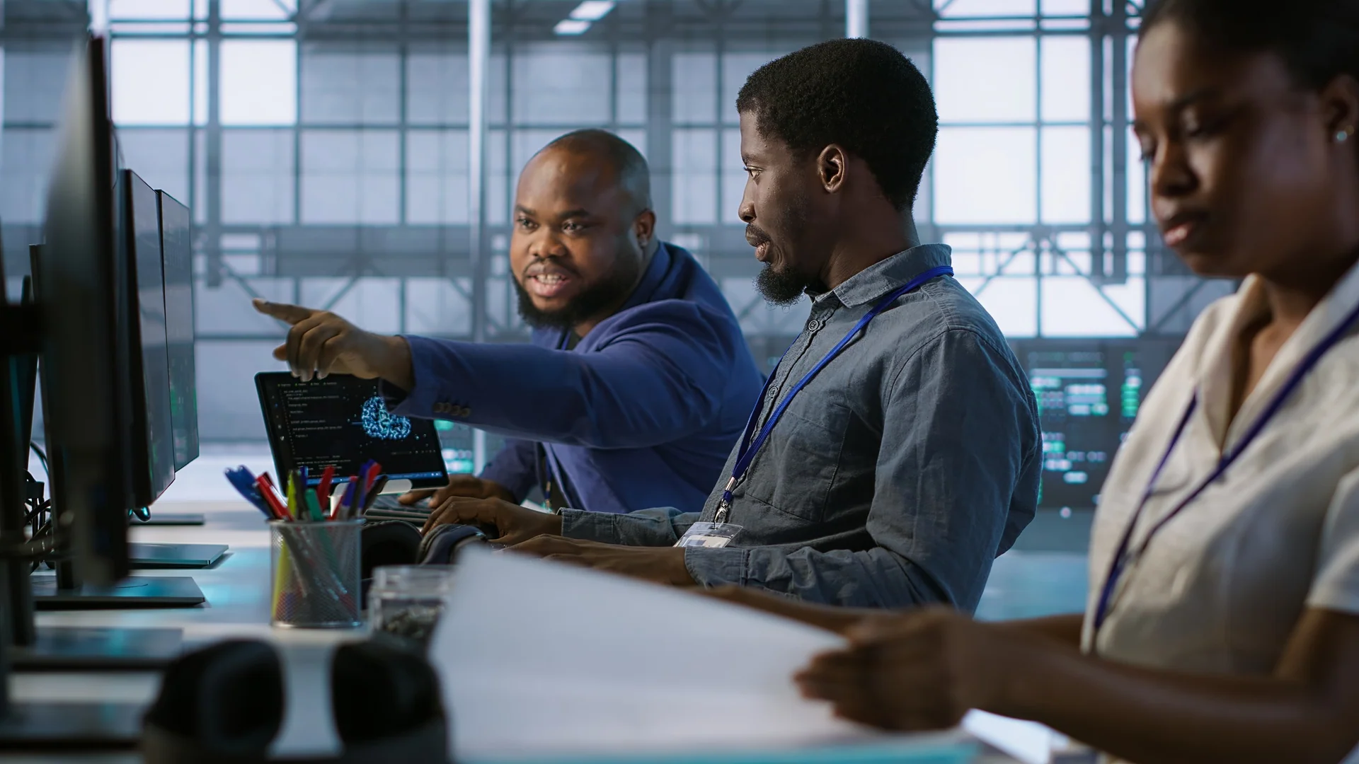 Engineers discussing code together at their workstations